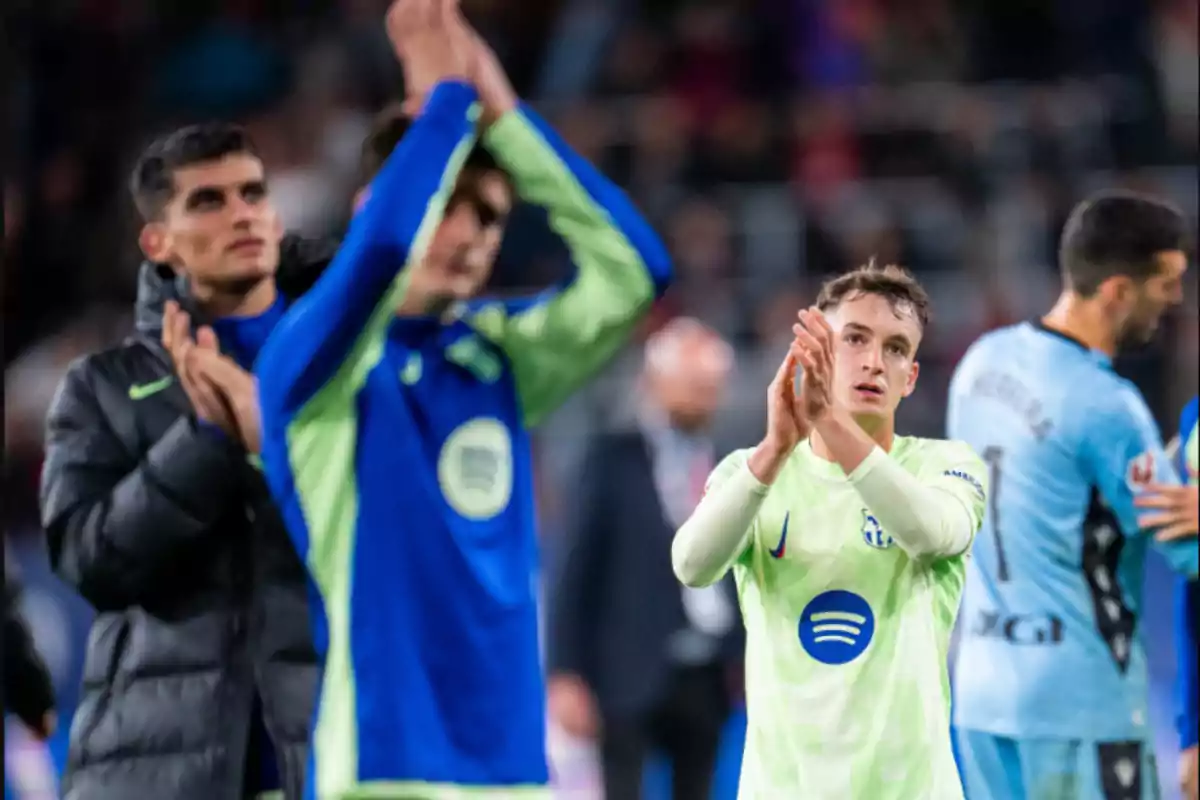 Jugadores de fútbol aplaudiendo al final de un partido.