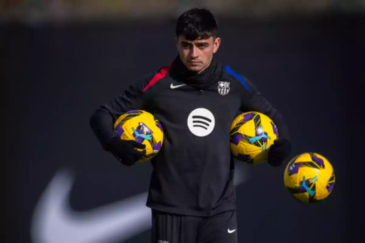 A soccer player in a dark uniform holds three yellow balls. A soccer player in a dark uniform holds three yellow balls.