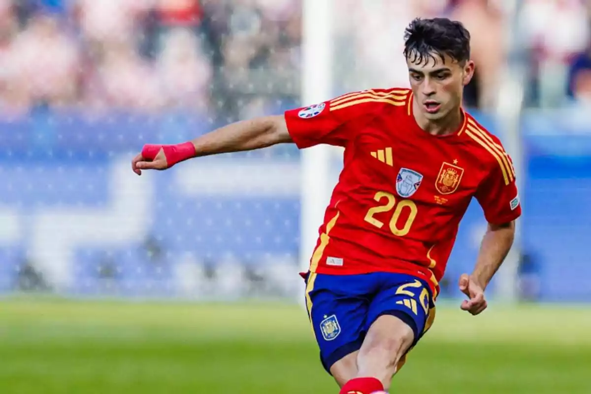 Un jugador de fútbol con la camiseta roja de la selección española y el número 20 en acción durante un partido.