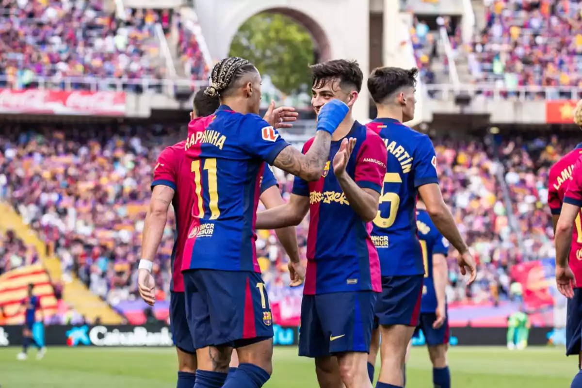 Jugadores de fútbol del FC Barcelona celebrando en el campo durante un partido con el estadio lleno de espectadores. Jugadores de fútbol del FC Barcelona celebrando en el campo durante un partido con el estadio lleno de espectadores.