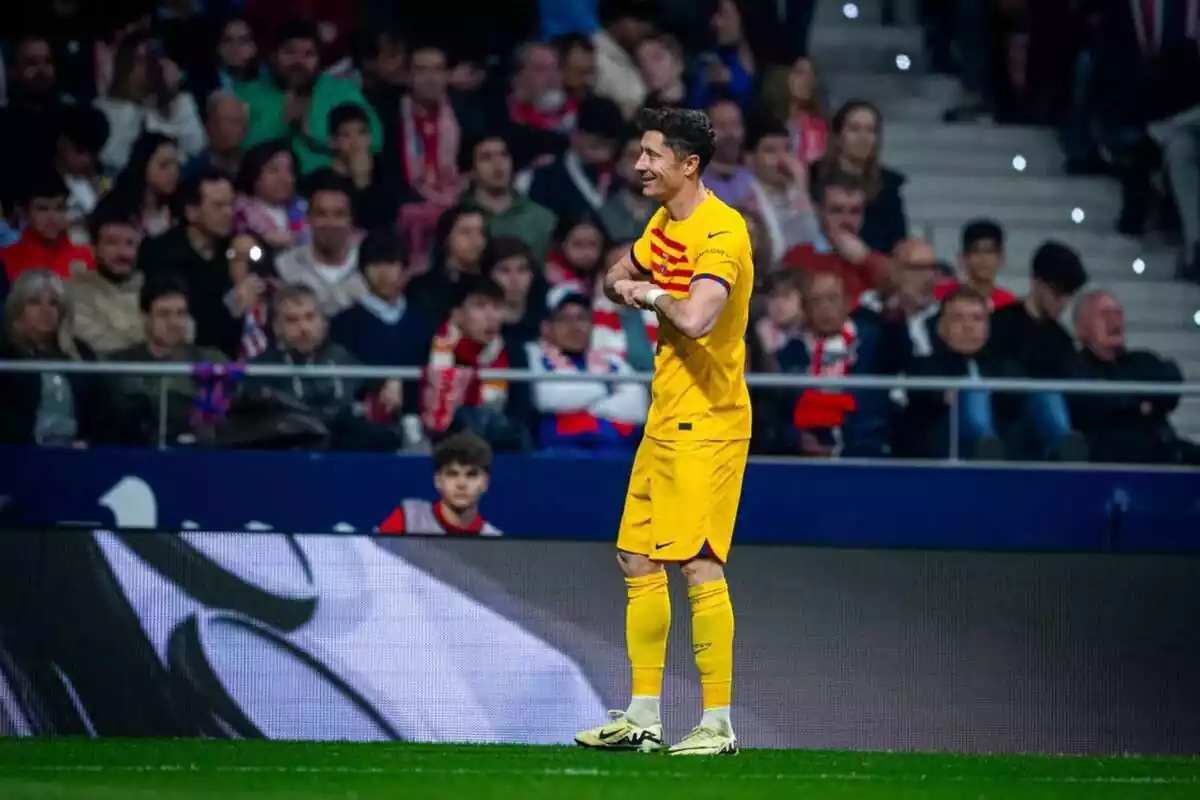Robert Lewandowski en un partido ante el Atlético de Madrid con la camiseta amarilla del FC Barcelona celebrando un gol