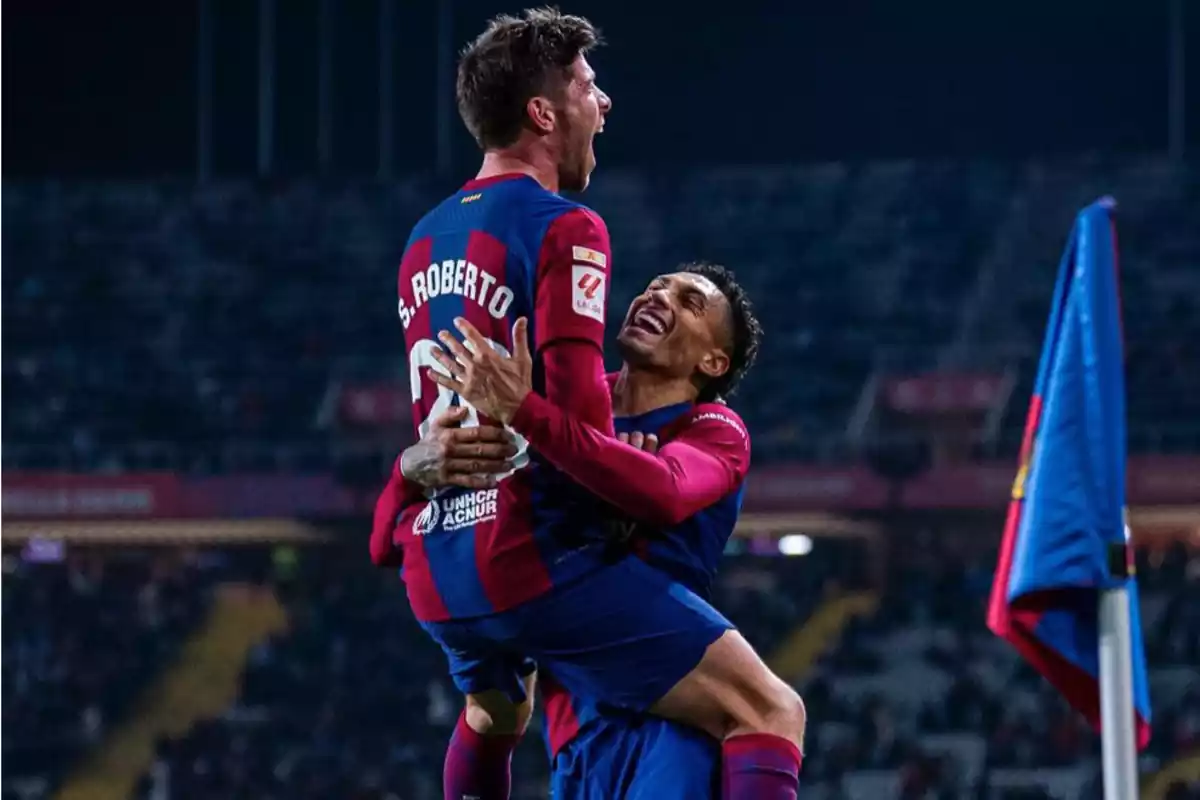Sergi Roberto Y Raphinha vestidos con la camiseta azulgrana del Barça abrazados en frente del banderín de córner celebrado un gol