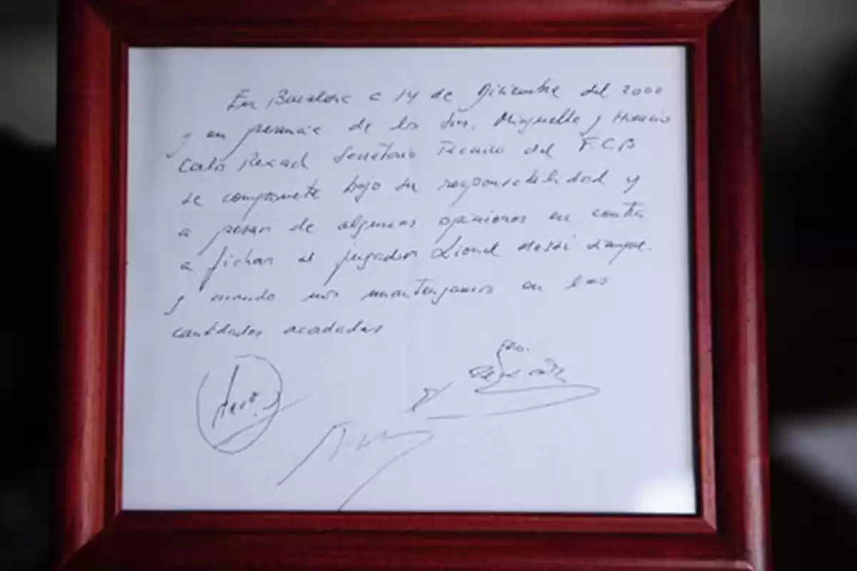Una servilleta con texto escrito en ella, firmada y enmarcada. Fue el primer contrato de Messi