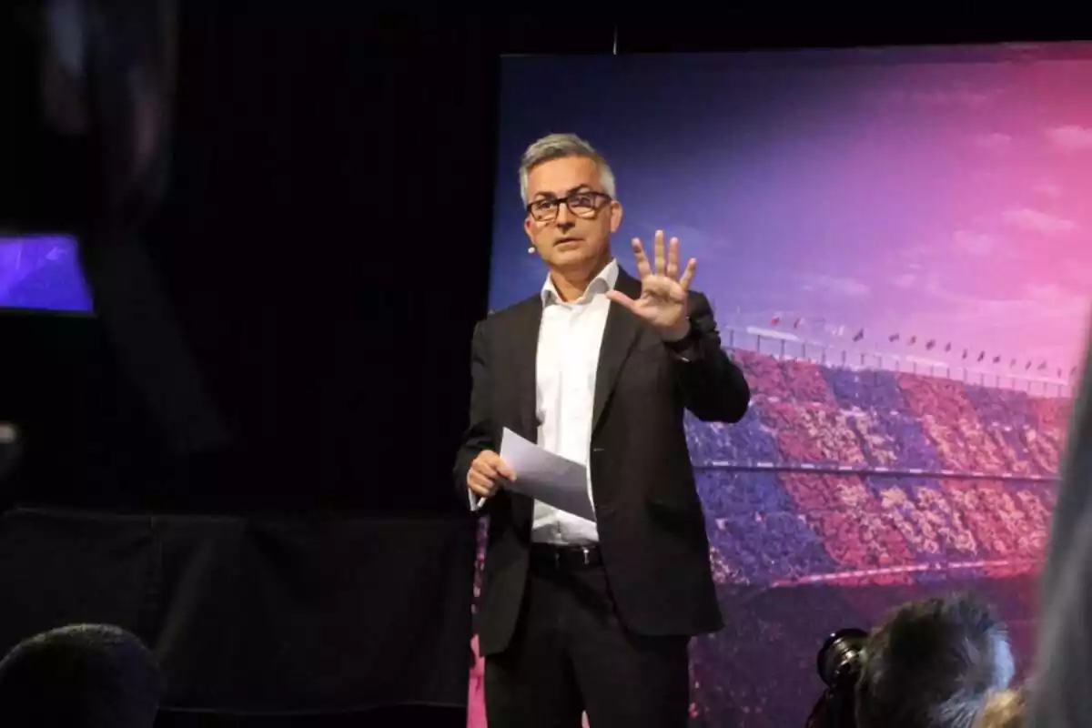 Víctor Font, excandidato a la presidencia del FC Barcelona, en una conferencia de prensa con un papel en una mano y levantando la otra.