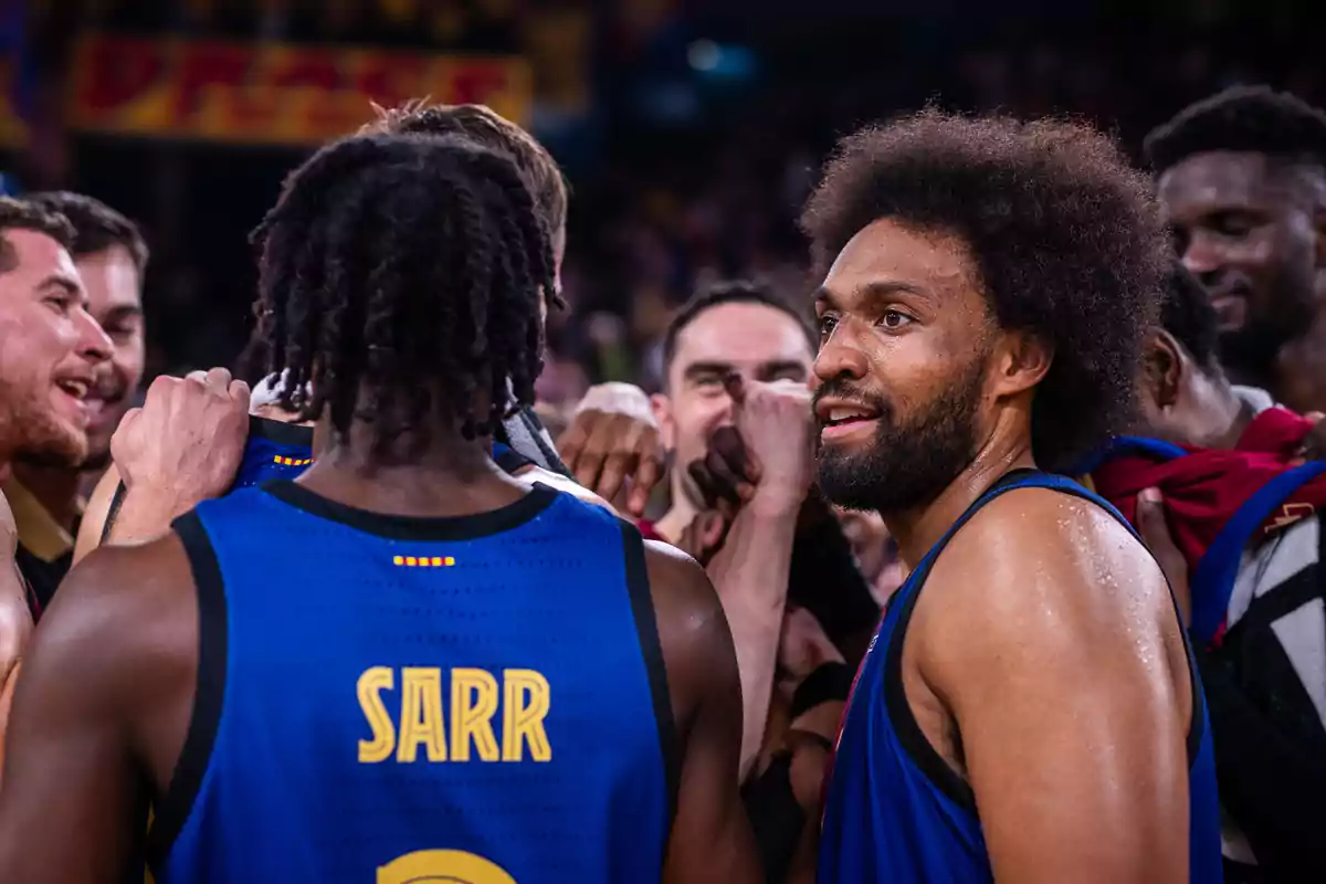 Jugadores de baloncesto celebrando en grupo en la cancha.